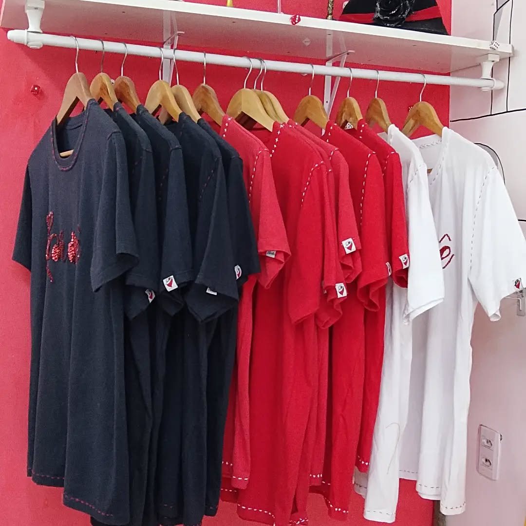 Arara com camisetas pretas, vermelhas e brancas com bordados e costura decorativa
